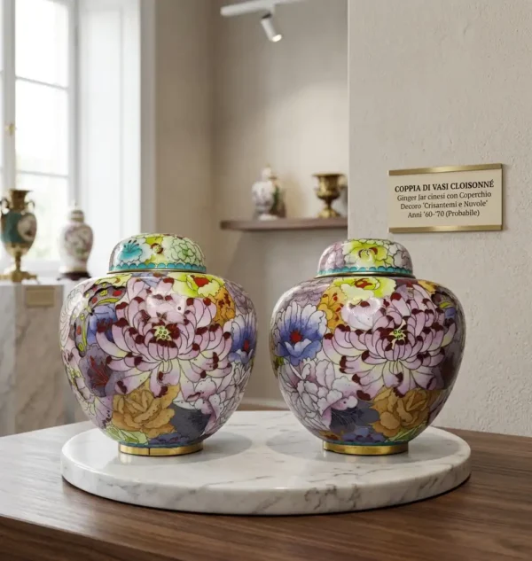 Coppia di ginger jar cloisonne cinesi con coperchio e decoro di crisantemi viola, esposta su un piedistallo di marmo in una galleria d'arte con un cartellino descrittivo.