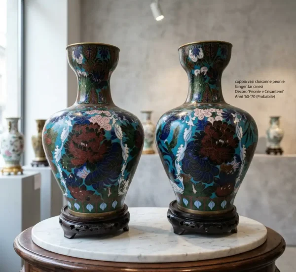 Coppia di vasi cloisonne cinesi azzurri con decoro floreale di peonie e crisantemi, poggiati su basi in legno scolpito in galleria.